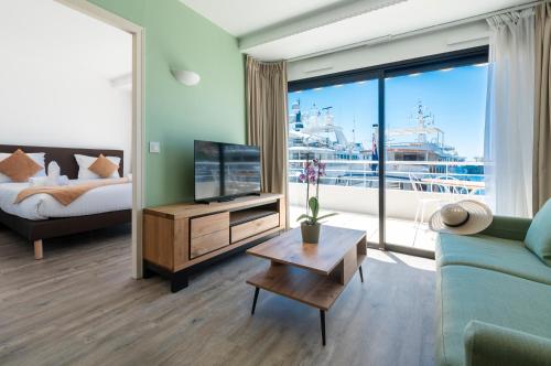 a living room with a couch and a large window at Résidence Cap Winston in Cap d'Ail