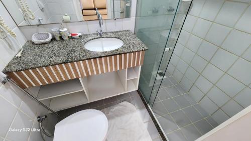 a bathroom with a toilet and a sink and a shower at GuarapariResidence in Guarapari