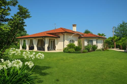 una casa con un prato verde davanti di Villa Forte Dei Marmi, Pool & Garden a Forte dei Marmi