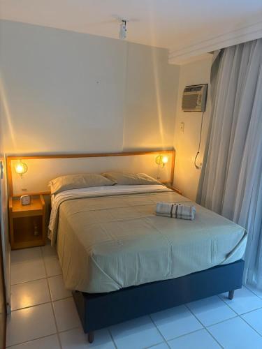 a bedroom with a large bed with two towels on it at GuarapariResidence in Guarapari