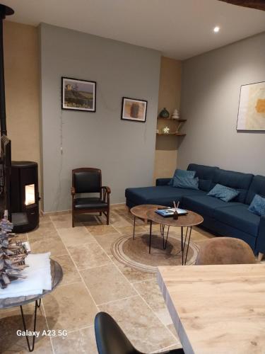 salon z niebieską kanapą i stołem w obiekcie Gîte L'Encantada w mieście Vic-Fezensac