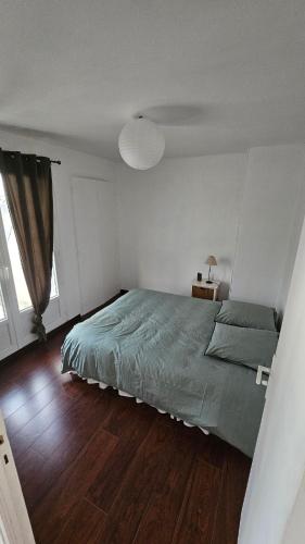 - une chambre avec un lit vert et du parquet dans l'établissement Centre ville Concarneau, à Concarneau