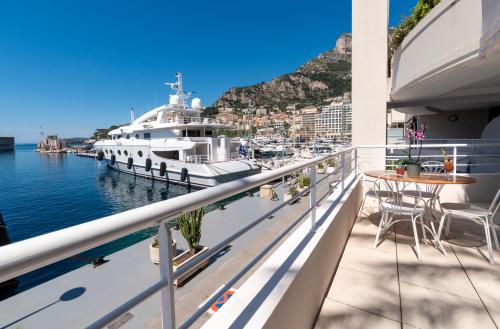 a balcony with a boat docked at a marina at Résidence Cap Winston in Cap d'Ail