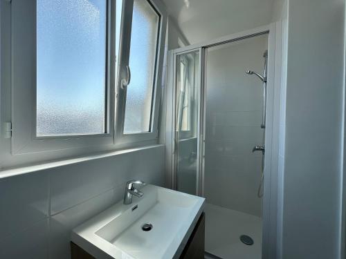 une salle de bain blanche avec un lavabo et une douche dans l'établissement Cozy cocoon in Recouvrance, à Brest