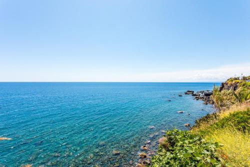 a view of the ocean from a cliff at Holiday Home Castello in Aci Castello