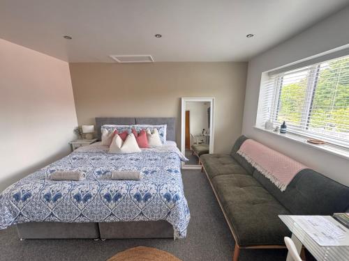 a bedroom with a bed and a couch at Abbey’s Inn in Cheadle