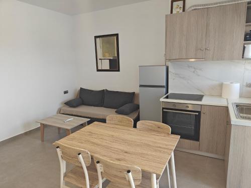 a kitchen and living room with a table and a couch at Chrissos apartment in Agios Padeleimon