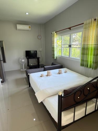 a bedroom with a bed with two tea cups on it at Wandee Resort Bankrut in Ban Krut