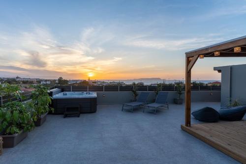a patio with chairs and a table on a roof at MD Horizon with private Jacuzzi near the beach in Anissaras