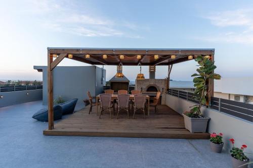 a wooden deck with chairs and a fireplace on a roof at MD Horizon with private Jacuzzi near the beach in Anissaras