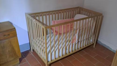 ein Kinderbett mit Kissen in einem Zimmer in der Unterkunft Quattro stagioni appartamento Inverno in Castiglione del Lago