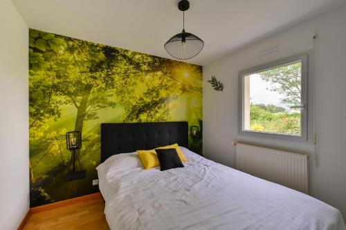 a bedroom with a bed with a large painting on the wall at La Maison d'Herbignac - Grand Jardin in Herbignac
