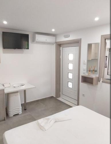 a white room with a bed and a desk at Villa Morena in Mursi