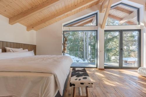 グレヘンにあるLuxury chalet with panoramic views, sauna, hot tub & cinemaのベッドと大きな窓のある寝室