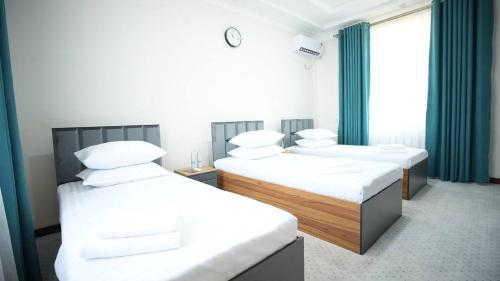 Кровать или кровати в номере Bmb Village Jizzakh Hotel