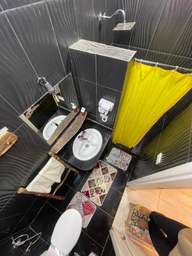 a black and yellow bathroom with a toilet and a sink at Skyrock Dahab in Dahab