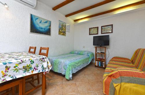 a bedroom with two beds and a tv and a chair at Apartments Suzi 2381 in Peroj