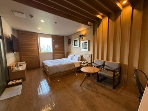 a bedroom with a bed and a table and a chair at Venice Hotel in Ulsan