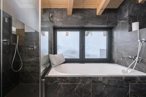 グレヘンにあるLuxury chalet with panoramic views, sauna, hot tub & cinemaのバスタブと窓のあるバスルーム
