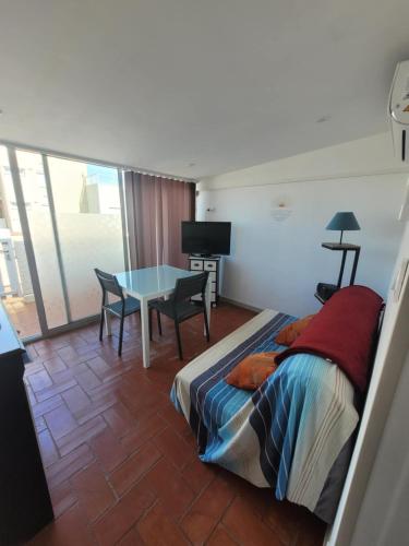 une chambre avec un lit et une table avec une télévision dans l'établissement Le studio 29, au Barcarès