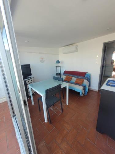 un salon avec une table et un lit dans l'établissement Le studio 29, au Barcarès