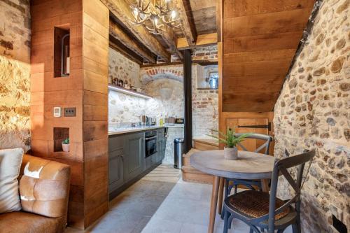 a kitchen with wooden walls and a table and chairs at Toll Barn, St Osyth Priory in Colchester