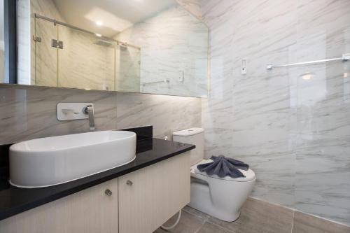 a white bathroom with a sink and a toilet at Sea View Apartment A32 in Kamala Ocean Residence just 450m from Kamala Beach in Kamala Beach