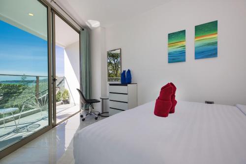 a bedroom with a white bed with a red object on it at Sea View Apartment A32 in Kamala Ocean Residence just 450m from Kamala Beach in Kamala Beach