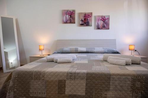 a bedroom with a large bed with two lamps and two beds sidx sidx sidx sidx at Villa Marika in Fontane Bianche