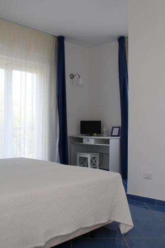 Marina di MonasteraceにあるAgriturismo biologico 'A Lanternaのベッドと机と窓のある寝室