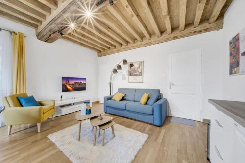 un salon avec un canapé bleu et une table dans l'établissement Climats des Échaliers, à Beaune