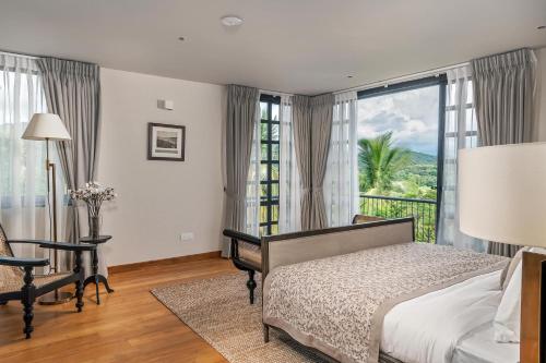 a bedroom with a bed and a desk and a window at The Alfred Digana by The One Group of Hotels in Digana
