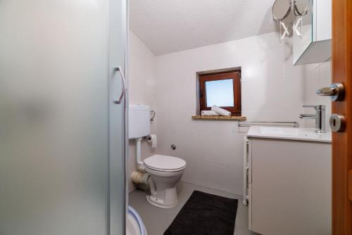 a bathroom with a toilet and a sink and a mirror at House Poljica with a pool in Poljica
