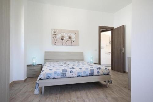 a bedroom with a bed and a painting on the wall at Villa Marika in Fontane Bianche