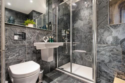 a bathroom with a shower and a toilet and a sink at Toll Barn, St Osyth Priory in Colchester