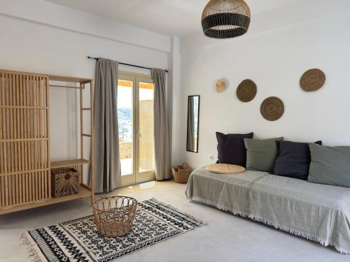 a living room with a bed and a window at Almyriki in Mylopotas