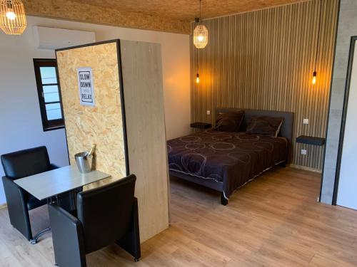 une chambre avec un lit et une table et une salle à manger dans l'établissement Gîte NATURISTE Le Jardin Des Hirondelles, à Blanzaguet-Saint-Cybard-le-Peyrat