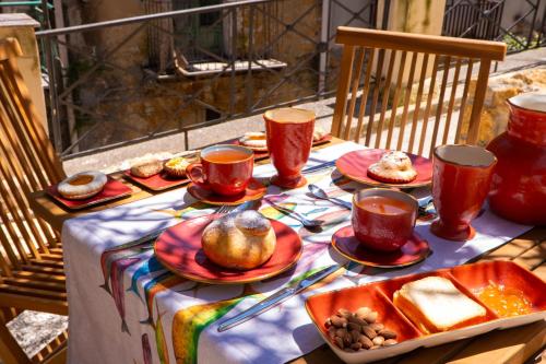 a table with cups and plates of food on it at Villa Amoroso - Ospitalità Mediterranea in Agrigento