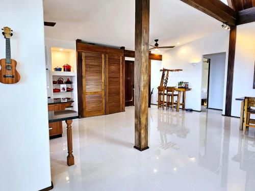 a living room with a table and a guitar at Breathtaking Oceanfront Home on Lava Rock Beach in Pahoa