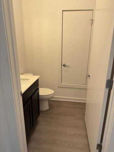 a bathroom with a toilet and a glass shower door at cozy apartment in Leander in Leander