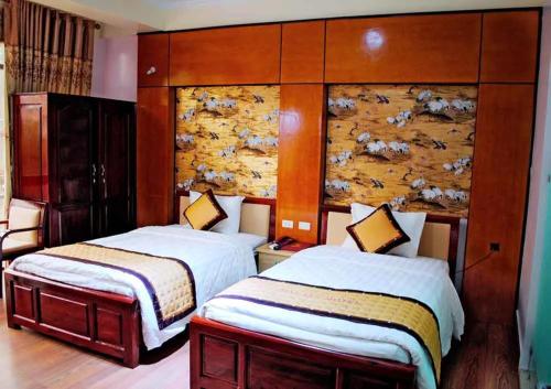 een hotelkamer met 2 bedden en een muur bij Hải Vân Hotel Điện Biên in Diện Biên Phủ