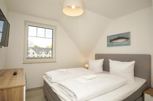 Giường trong phòng chung tại Rex Rugia FeWo15-7 mit Schwimmbad und Saunanutzung im AHOI-Erlebnisbad Sellin