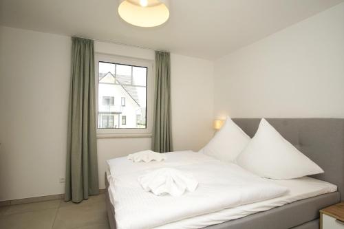 En eller flere senge i et værelse på Rex Rugia FeWo15-4 mit Schwimmbad und Saunanutzung im AHOI-Erlebnisbad Sellin