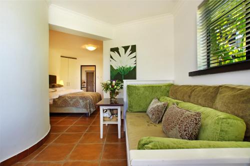 a living room with a couch and a bedroom at Dreamhouse Guest House in Hout Bay