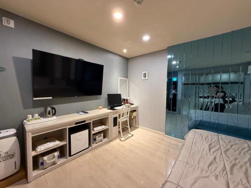 a living room with a flat screen tv on a wall at Venice Hotel in Ulsan