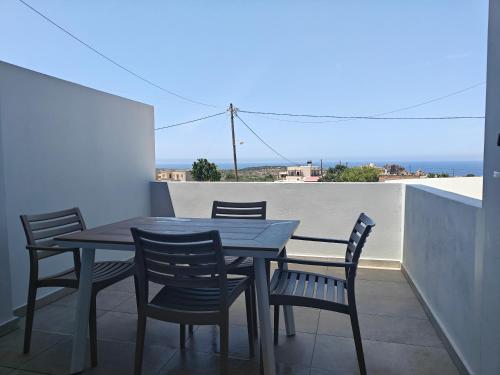 un tavolo e sedie su un balcone con vista di Chrissos apartment ad Áyios Pandeleḯmon