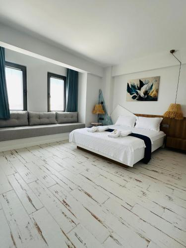 a white room with two beds and a couch at Dione Bozcaada in Bozcaada