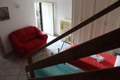 a living room with a red couch and a chair at La Casa nel Sole Poggio Bustone in Poggio Bustone