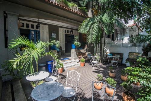 an outdoor patio with tables and chairs and plants at Ipanema Beach House in Rio de Janeiro