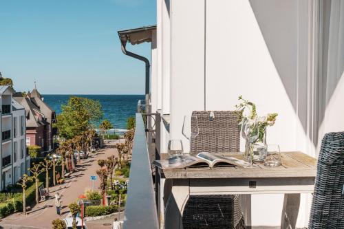 a table on a balcony with a view of the ocean at Hotel Meersinn - Binz in Binz